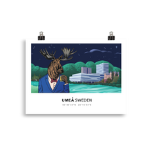 Load image into Gallery viewer, Poster of a moose in Umeå, Sweden, in front of the Ume älv and the Väven building